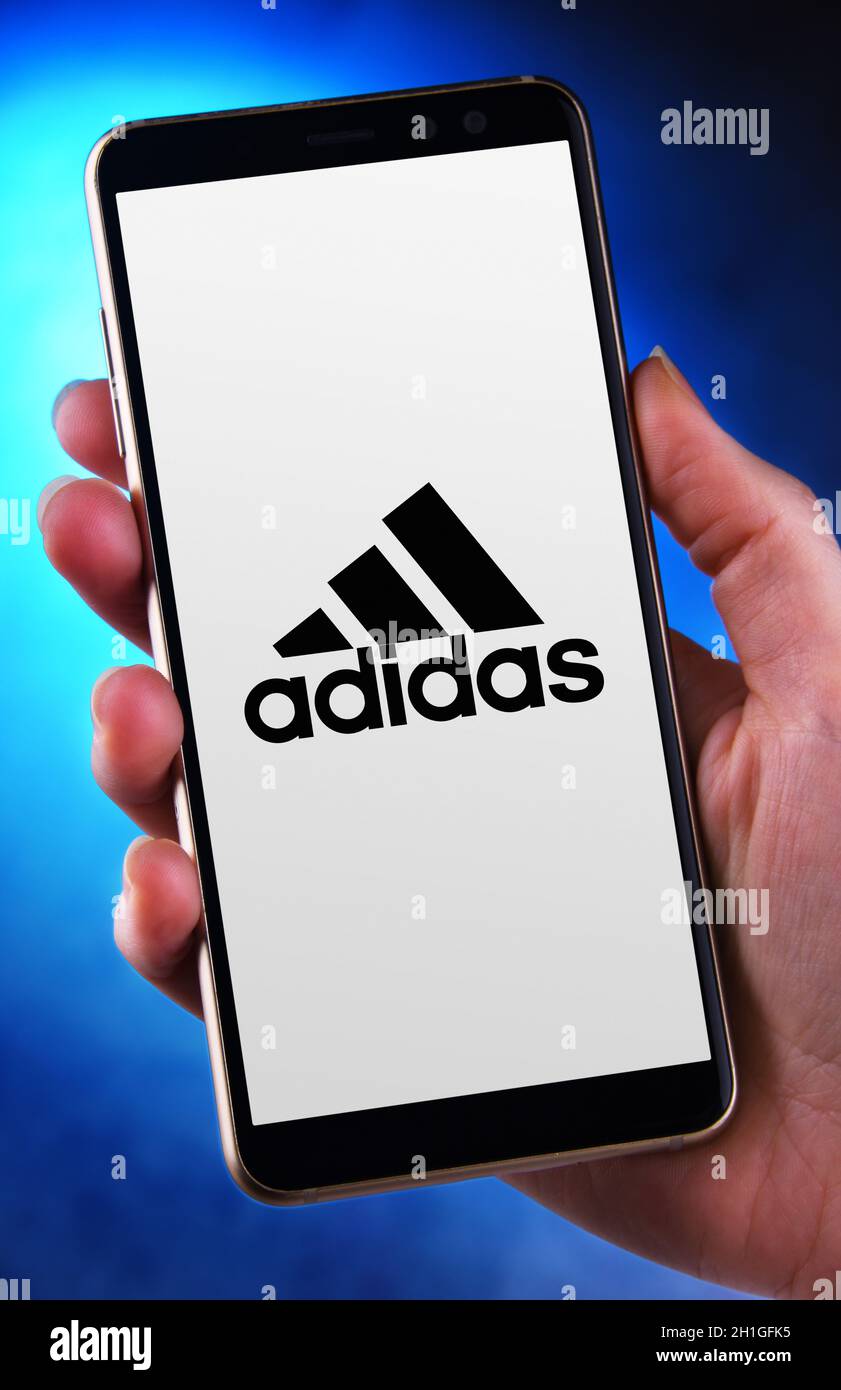 POZNAN, POL - JUN 12, 2020: Hand holding smartphone displaying logo of  Adidas, a German company, that designs and manufactures shoes, clothing and  acc Stock Photo - Alamy