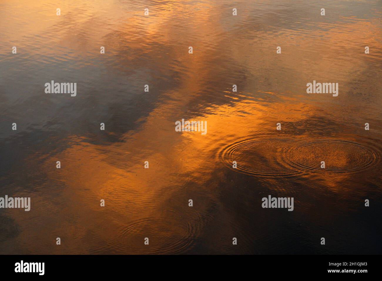 Abstract evening reflections of the clouds in the calm water. Stock Photo