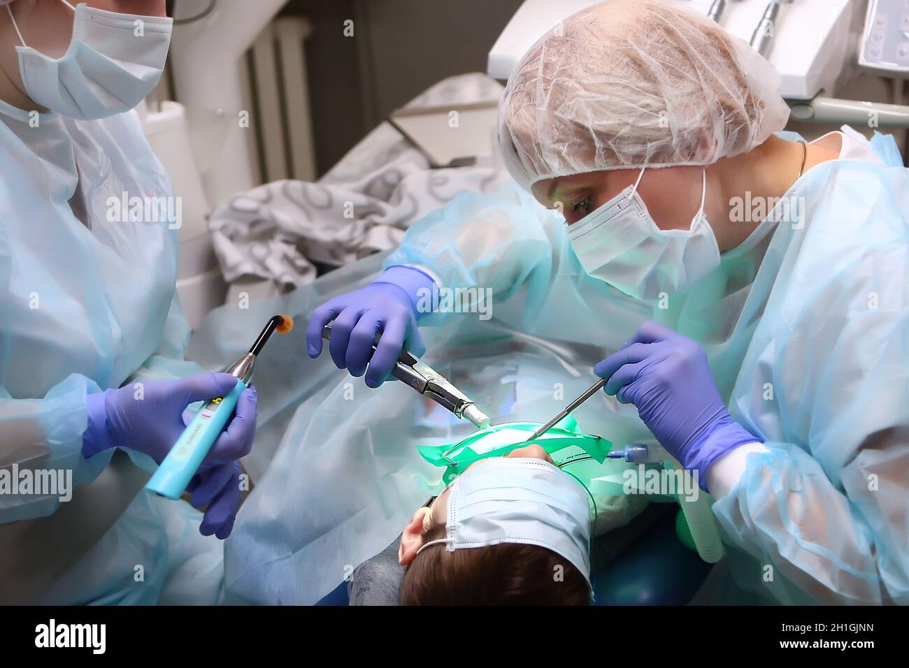 A pediatric dental surgeon treats a young boy's teeth under General anesthesia. Dental surgery