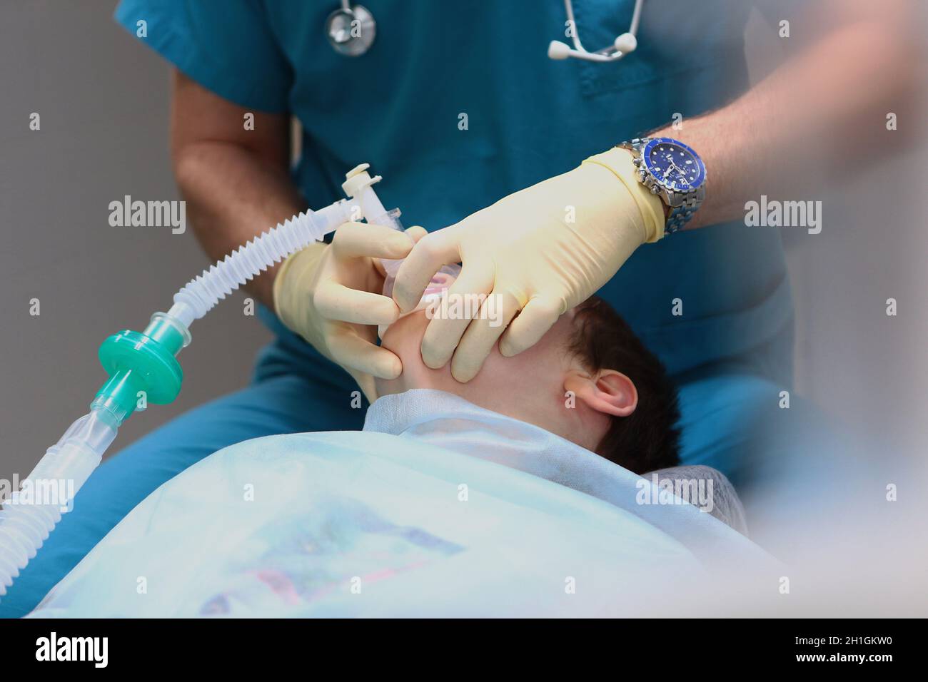 The anesthesiologist takes the child out of anesthesia. The end of the operation. Concept of health care and life saving. Copy space. An unrecognizabl Stock Photo