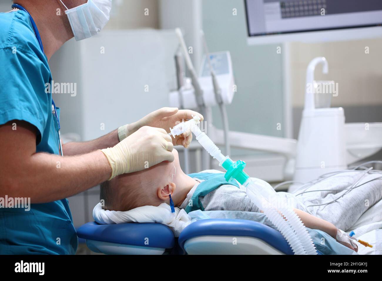 An anesthesiologist inserts a breathing tube into the trachea of a