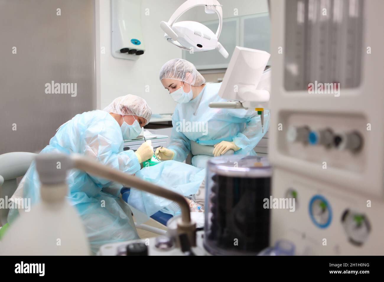 A doctor and an assistant perform dental surgery on a young child. Operation under General