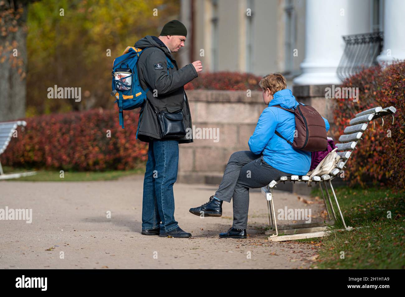 Krimulda, Latvia, October 10, 2021: tourists rest on a bench in the park at the entrance to the old manor house Stock Photo