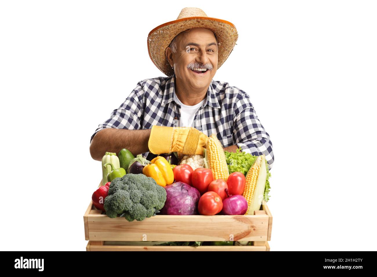 Mature farmer leaning on a crate full of fresh healthy vegetabales isolated on white background Stock Photo