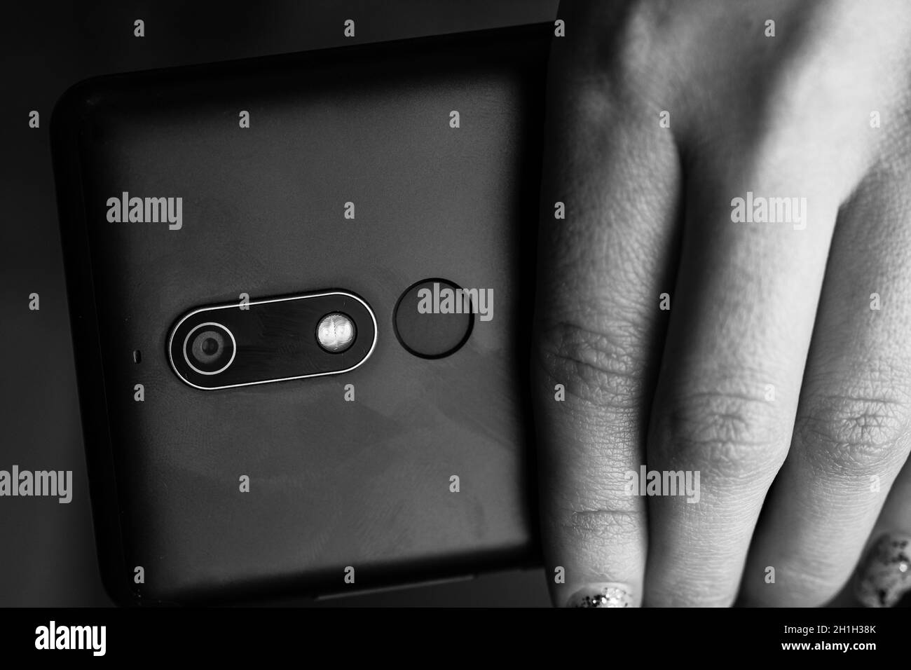 Woman hand holding a black smartphone in her hand. Black smartphone Stock Photo