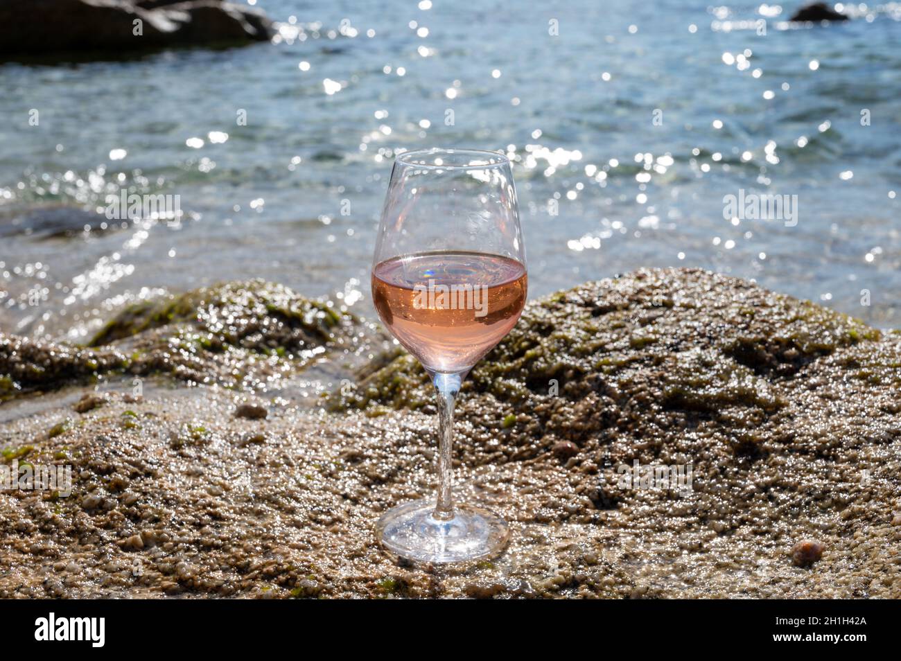 Summer time in Provence, glass of cold rose wine on sandy beach near Saint-Tropez in sunny day, Var department, France Stock Photo