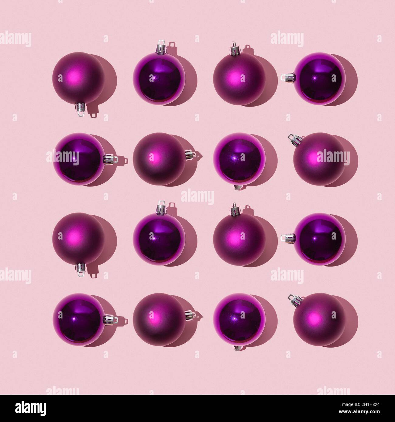 Sparkling bright christmas balls of purple color lie in the form of a square on a pink background, christmas holiday celebration concept, flat lay,  Stock Photo