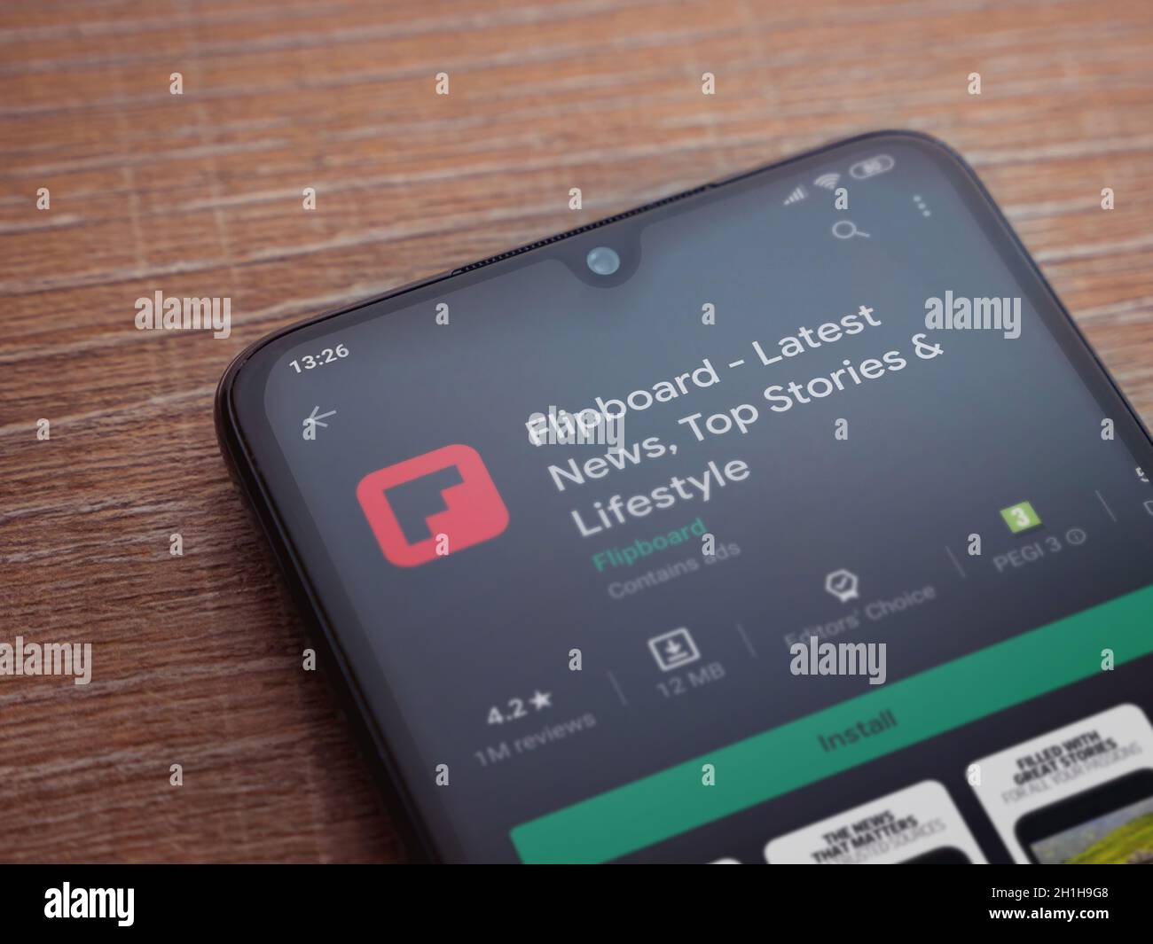 Lod, Israel - July 8, 2020: Flipboard app play store page on the display of a black mobile smartphone on wooden background. Top view flat lay with cop Stock Photo