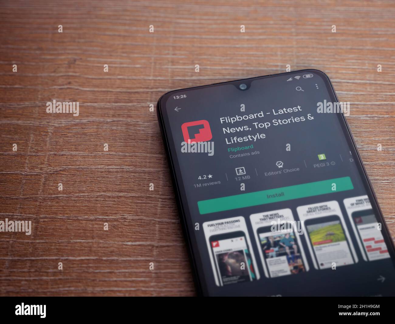Lod, Israel - July 8, 2020: Flipboard app play store page on the display of a black mobile smartphone on wooden background. Top view flat lay with cop Stock Photo