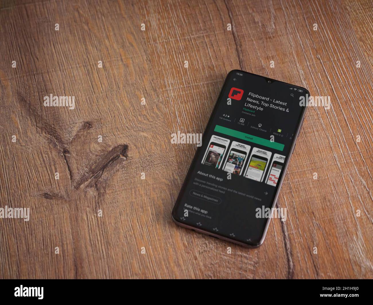 Lod, Israel - July 8, 2020: Flipboard app play store page on the display of a black mobile smartphone on wooden background. Top view flat lay with cop Stock Photo