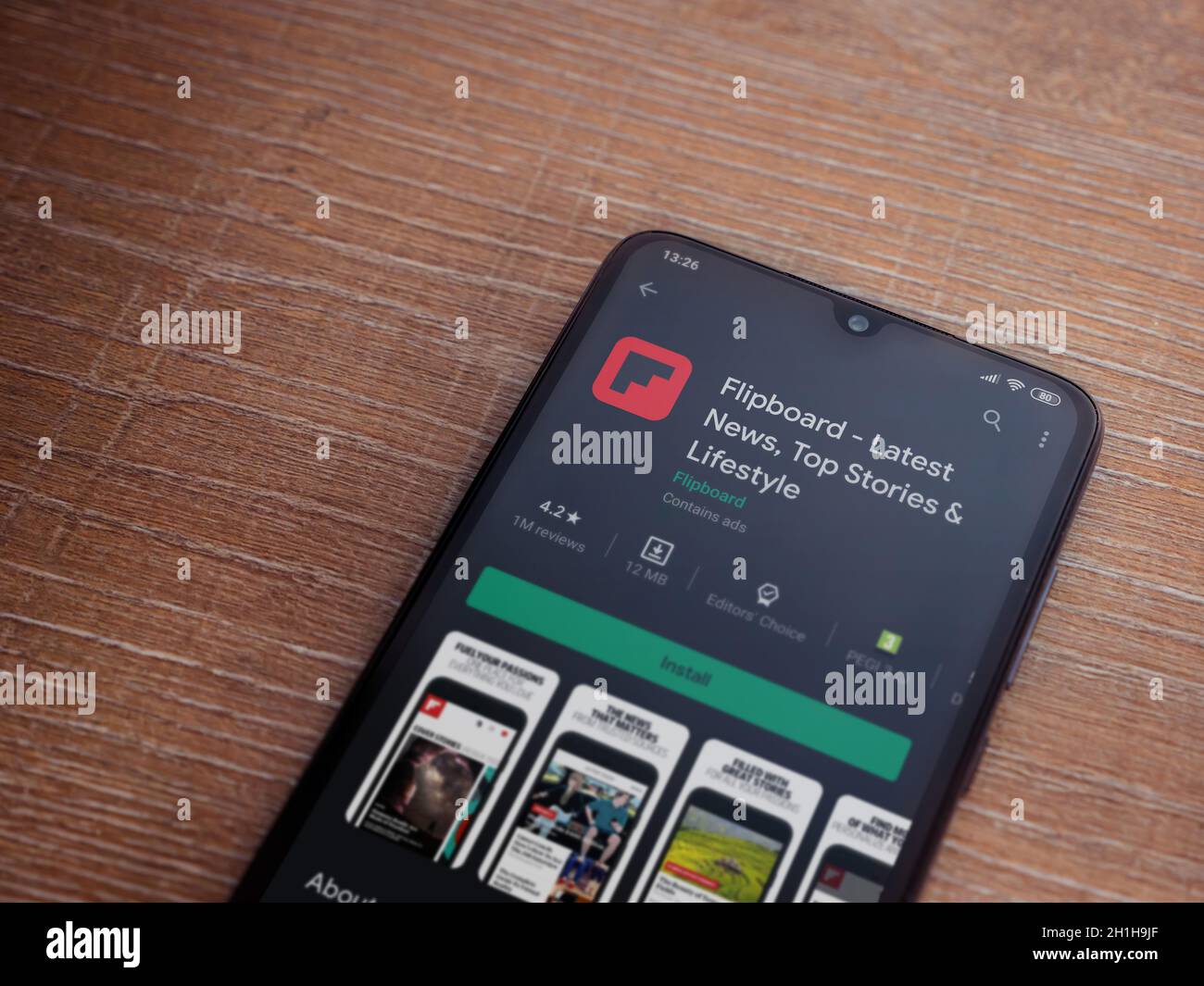 Lod, Israel - July 8, 2020: Flipboard app play store page on the display of a black mobile smartphone on wooden background. Top view flat lay with cop Stock Photo