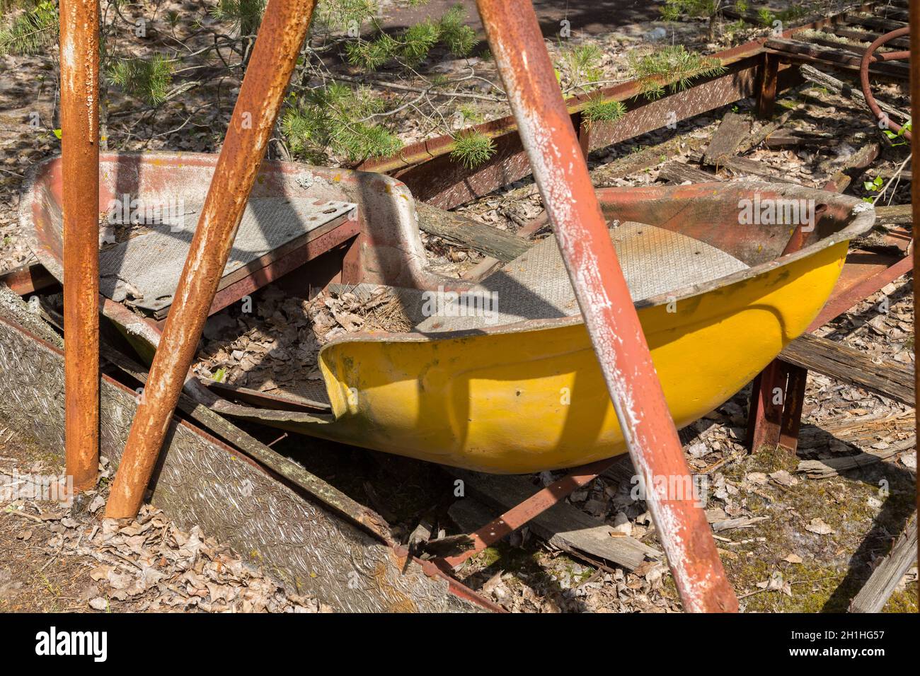 Old broken rusty metal radioactive children's electric wheel abandoned, the park of culture and recreation in the city of Pripyat, the Chernobyl disas Stock Photo