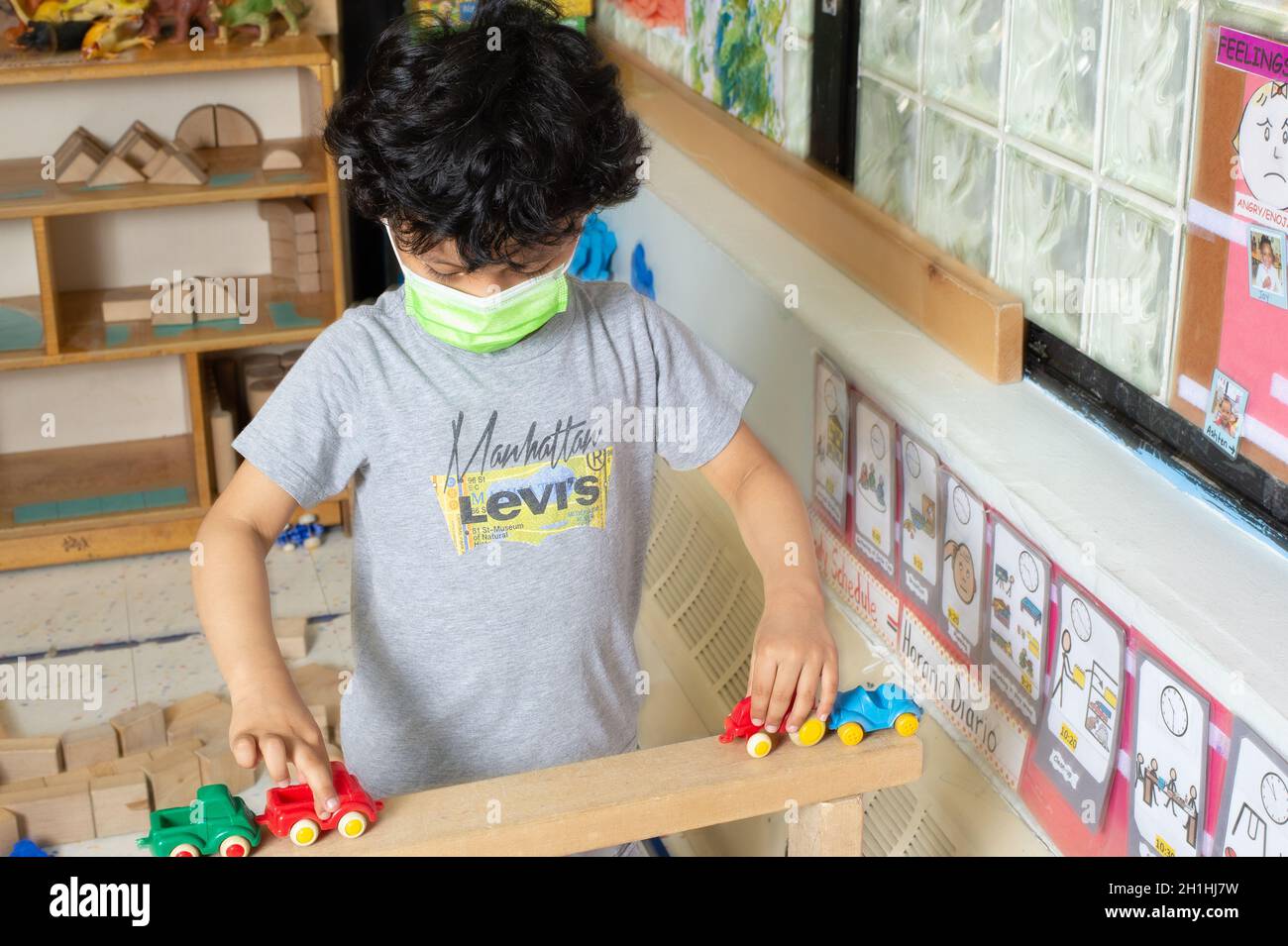 Education Preschool 4-5 year olds boy playing with toy vehicles on block structure he built Stock Photo