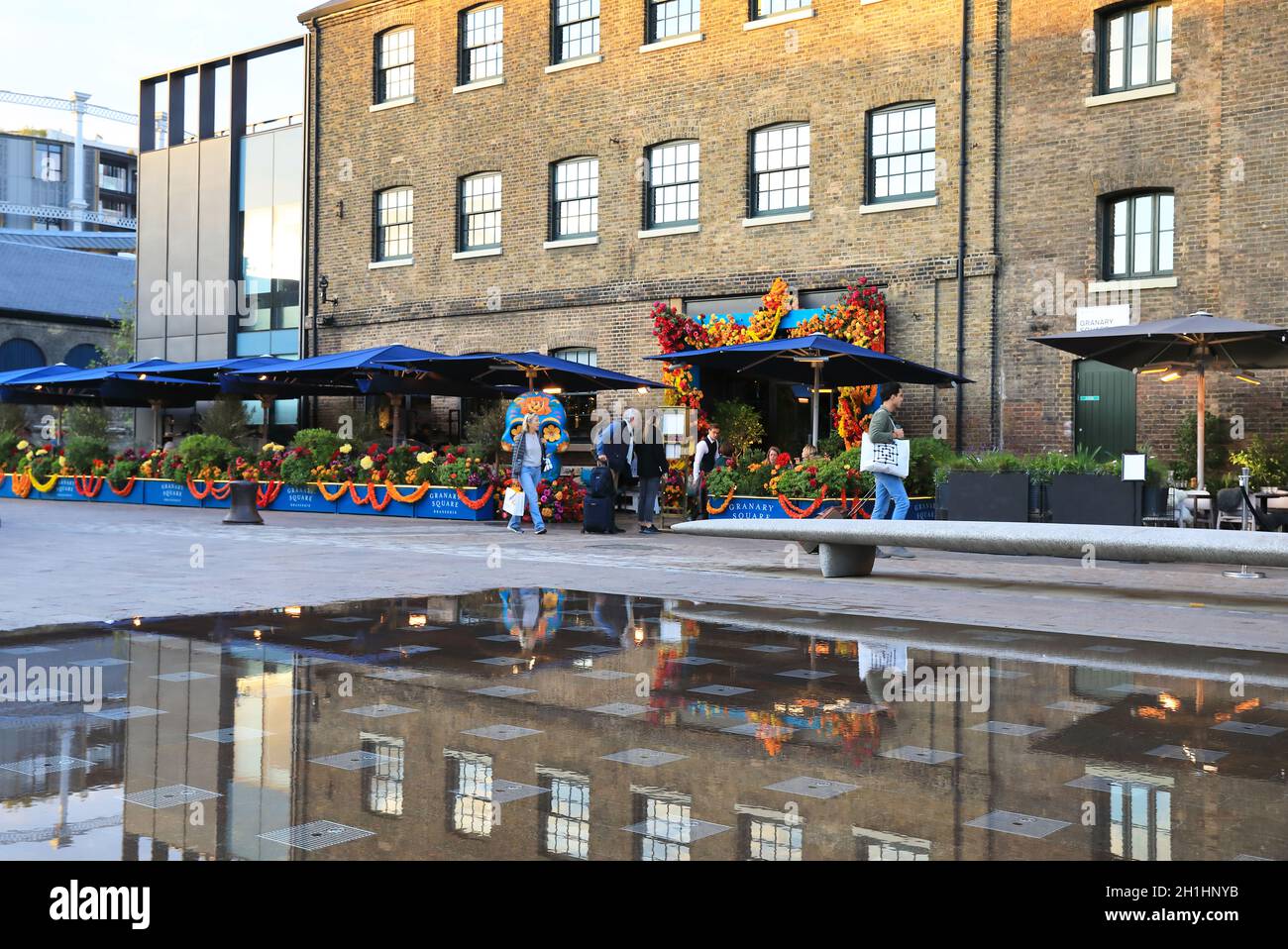 The Granary Square Brasserie underneath St Martins Central School of Art in the autumn sunshine, at Kings Cross, north London, UK Stock Photo