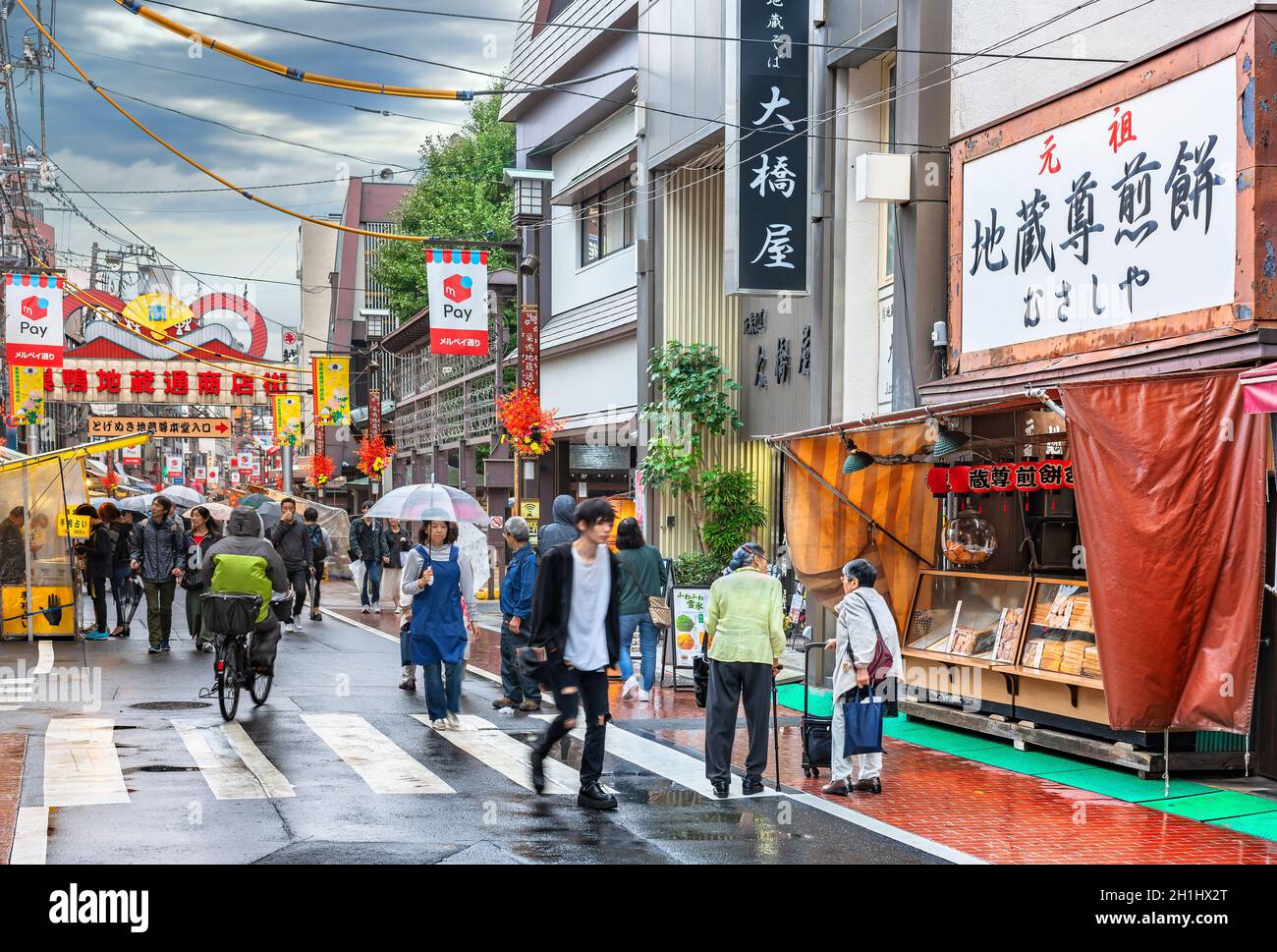 tokyo, japan - october 14 2019: Elderly with canes in front of a traditional Japanese Senbei rice cracker shop adorned with chochin lanterns in the Su Stock Photo