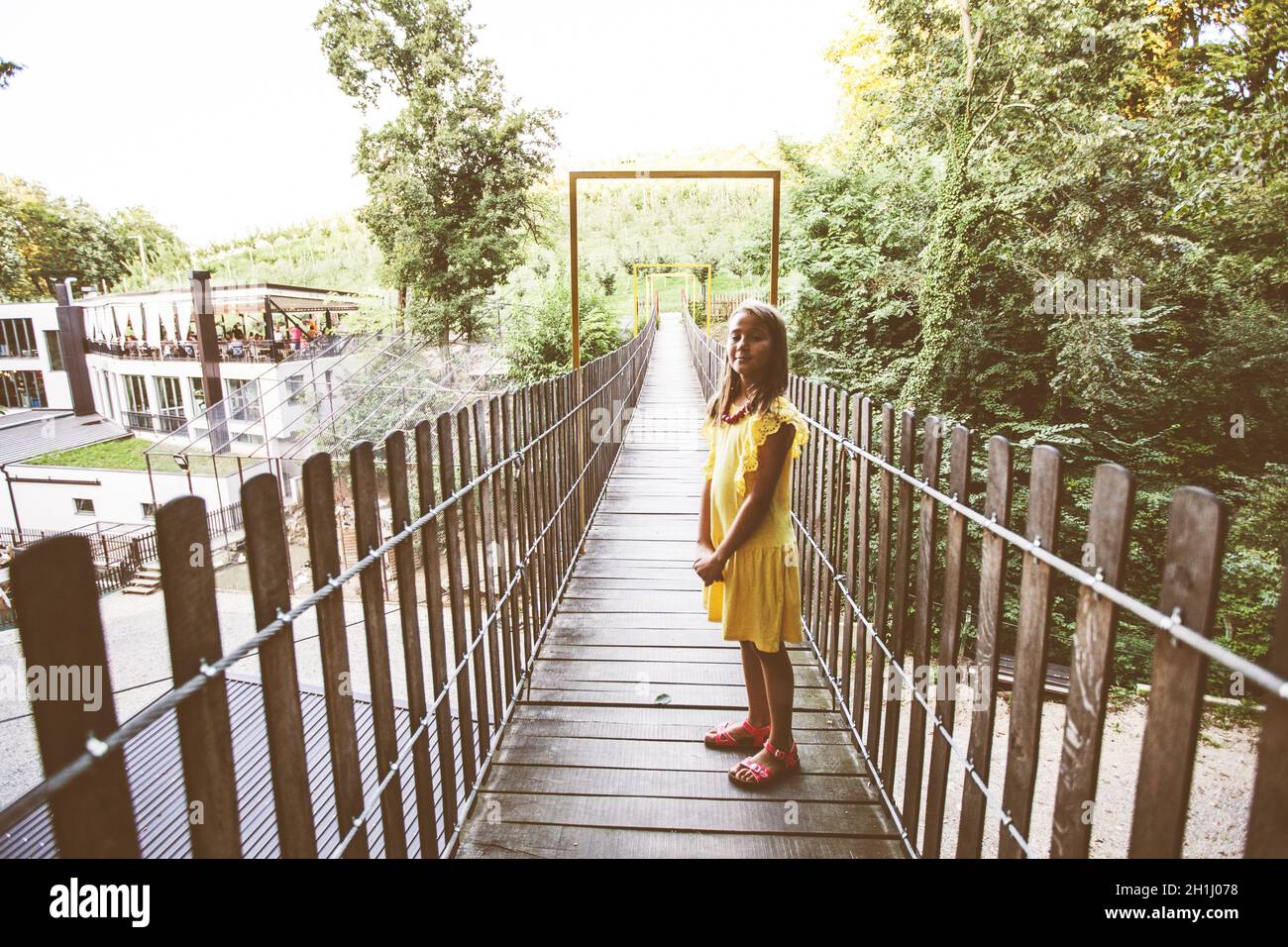 Portrait of Smiling Little girl crossing wooden suspension bridge Stock ...