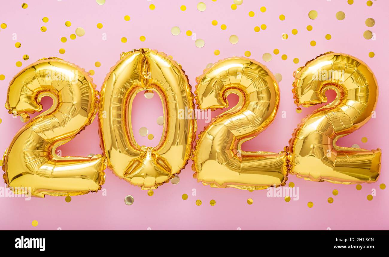 2022 year gold balloons text with confetti on pink color background. Happy New year 2022 lettering eve celebration. Merry Christmas Concept. Long web Stock Photo