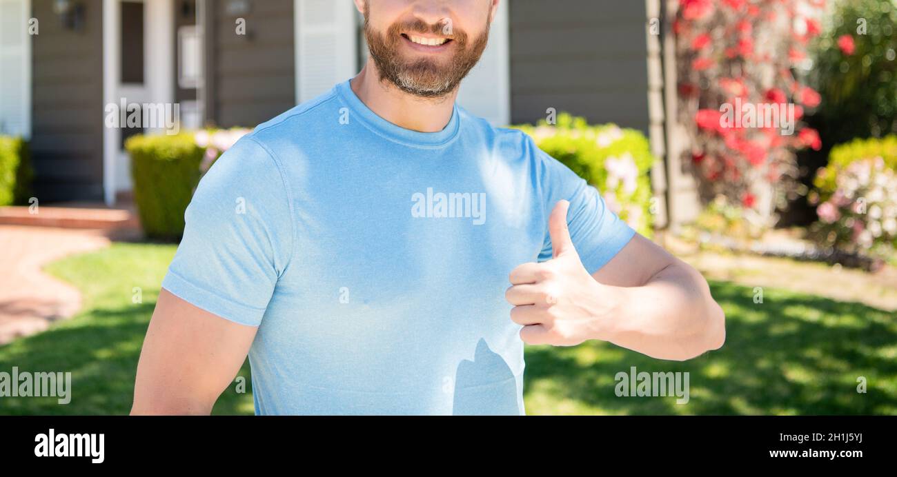 copped guy standing near house showing thumb up, perfection Stock Photo