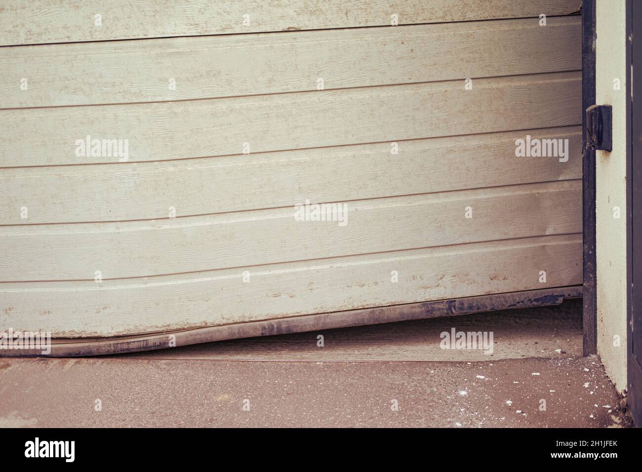 Damaged bent door that rises when opening a lift garage Stock Photo Alamy