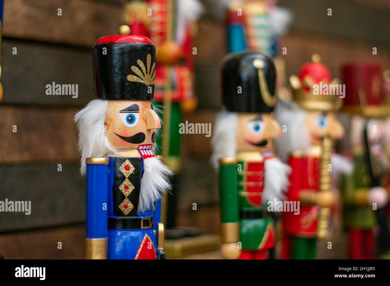 A Blue Nutcracker on a Dark Wooden Shelf With Other Nutcrackers In Line