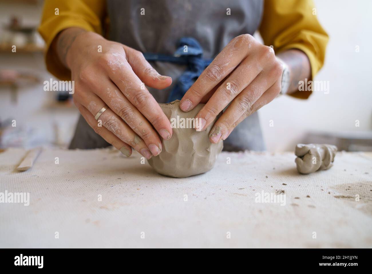 Work with your hands: artist female molding raw clay for sculpturing and shaping pottery or ceramics Stock Photo
