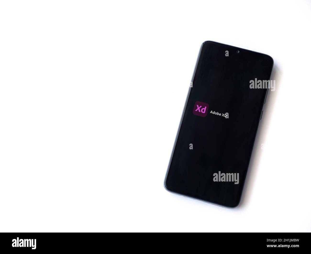 Lod, Israel - July 8, 2020: Adobe XD app launch screen with logo on the display of a black mobile smartphone isolated on white background. Top view fl Stock Photo