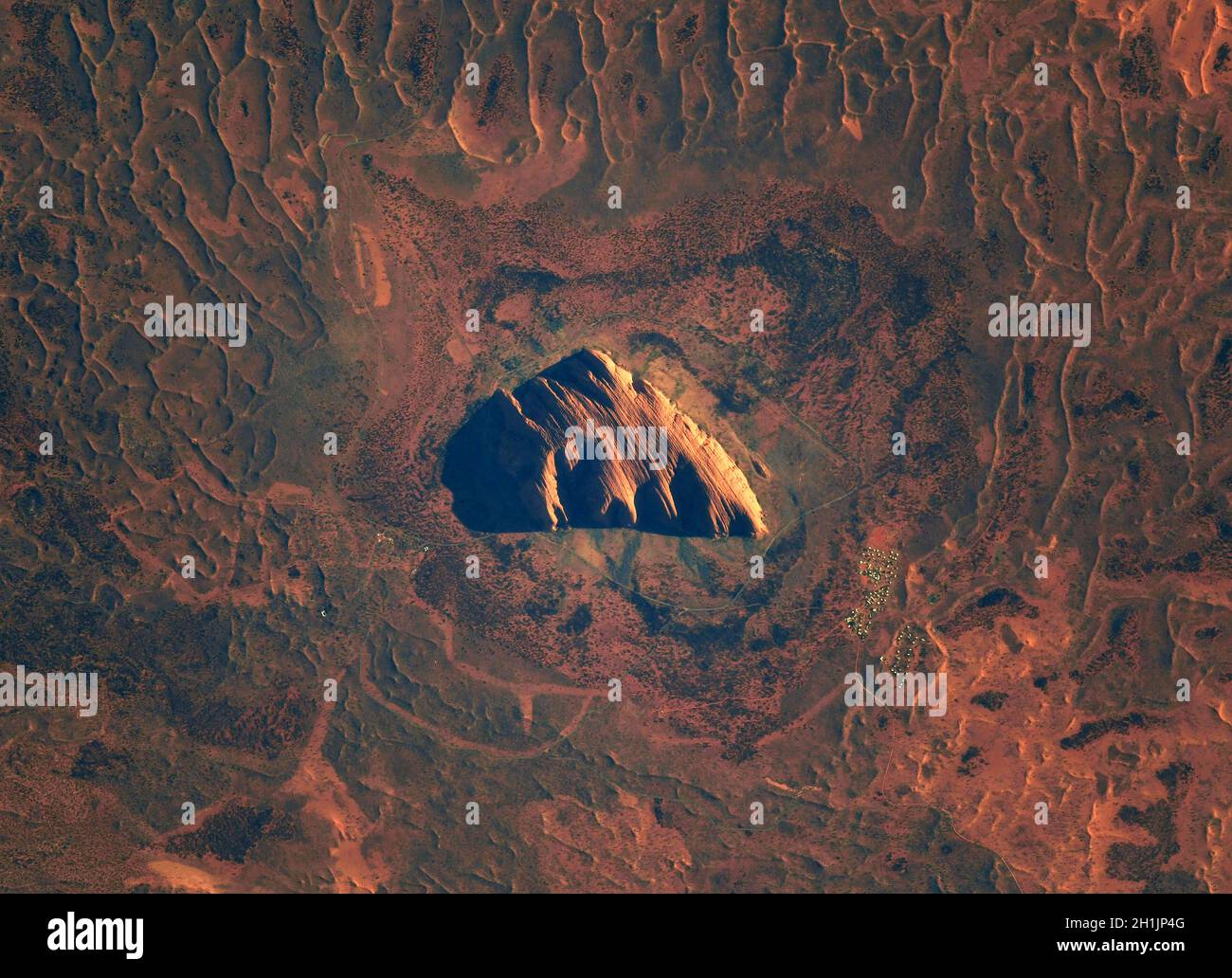 A view of Earth from the International Space Station: Uluru, formerly known as Ayers Rock, Australia in the morning. A revered sacred site.  An optimised and digitally enhanced version of a NASA/ ESA image. Mandatory Credit: NASA/ESA/T. Pesquet. NB: Usage restrictions: Not to be presented as an endorsement. Stock Photo