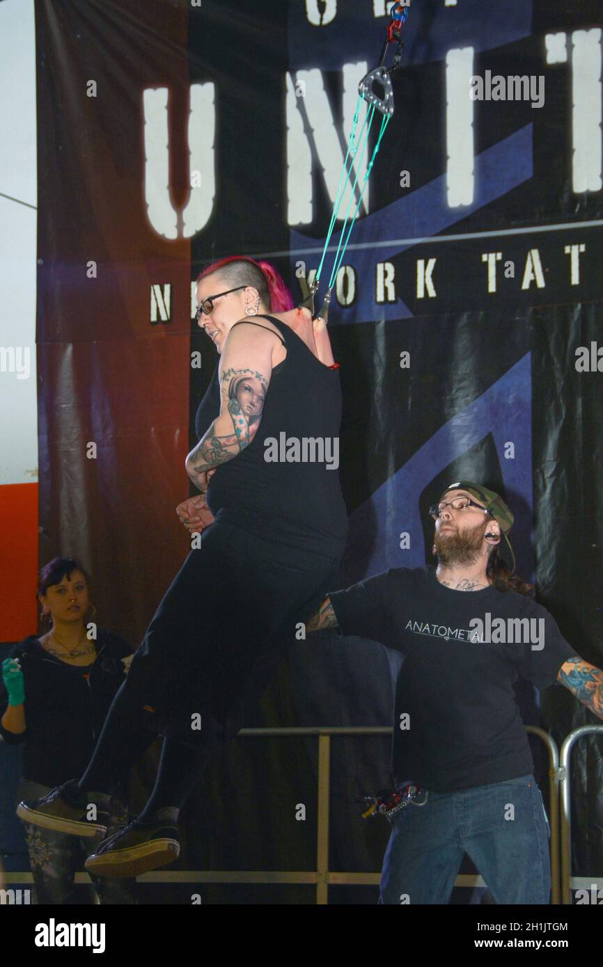 BODY SUSPENSION. A woman swings with giant hooks piercing her back,. At