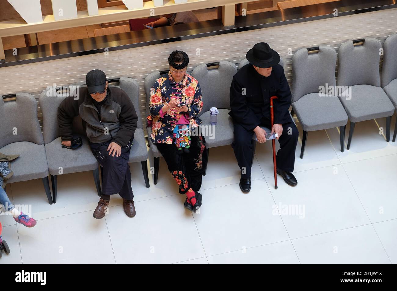 People resting in shopping mall interior. Multi luxury brand and restaurants inside, in Shanghai, China. Stock Photo