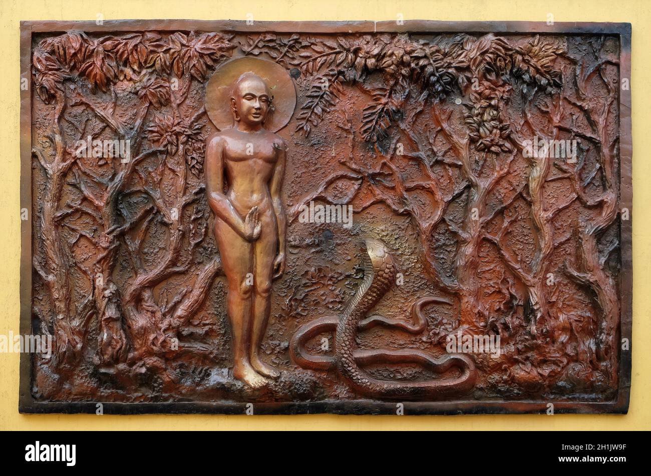 Love always wins anger and hatred: Bhagavan Mahavira enlightens a deadly poisonous Candkausika, Street bas relief on the wall of Jain Temple (also cal Stock Photo