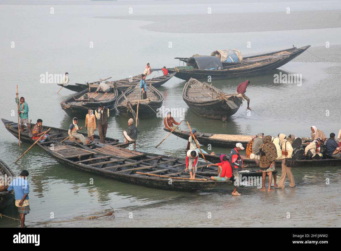 Wooden boat crosses the Matla River in Canning Town, West Bengal, India Stock Photo