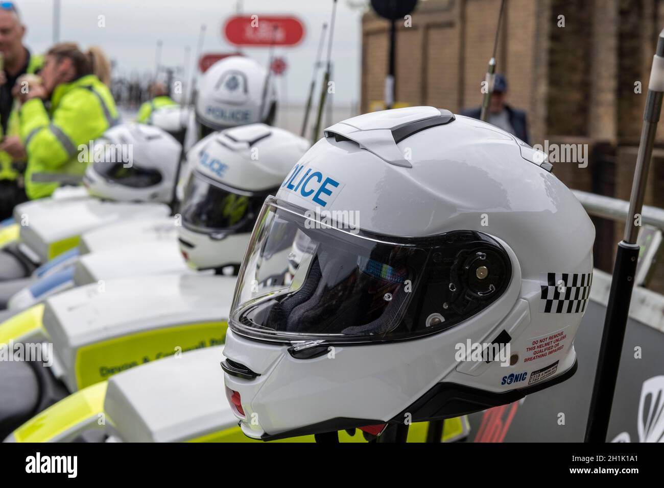 Police and event motorcycles ready to operate the rolling road blocks for the AJ Bell Women's Tour cycle race stage four through Essex. Police helmets Stock Photo