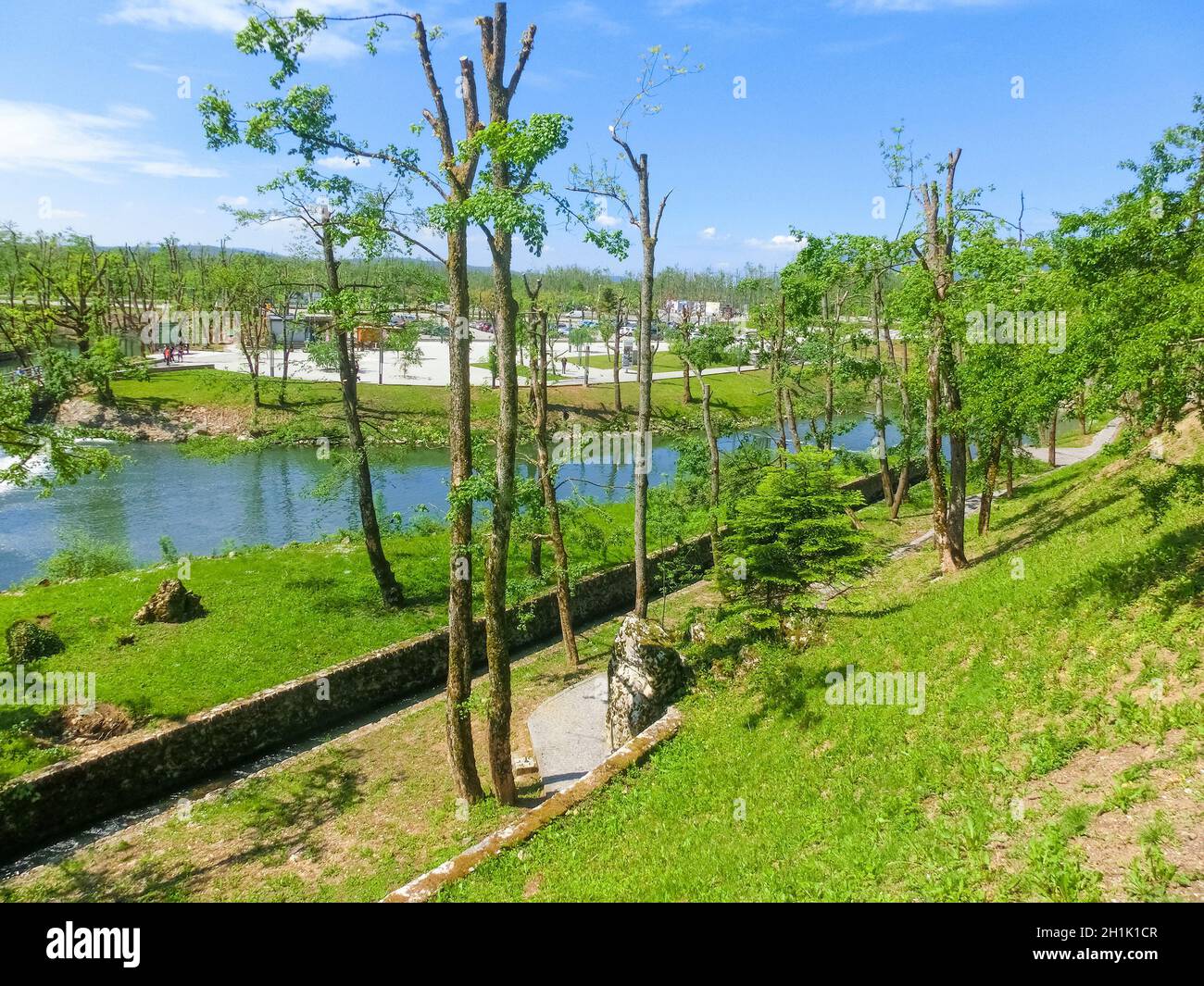 View on waterfall, mill in white building, pedestrian bridge in Park Postojna jama near Postojna Cave, famous attraction in Slovenia. Stock Photo