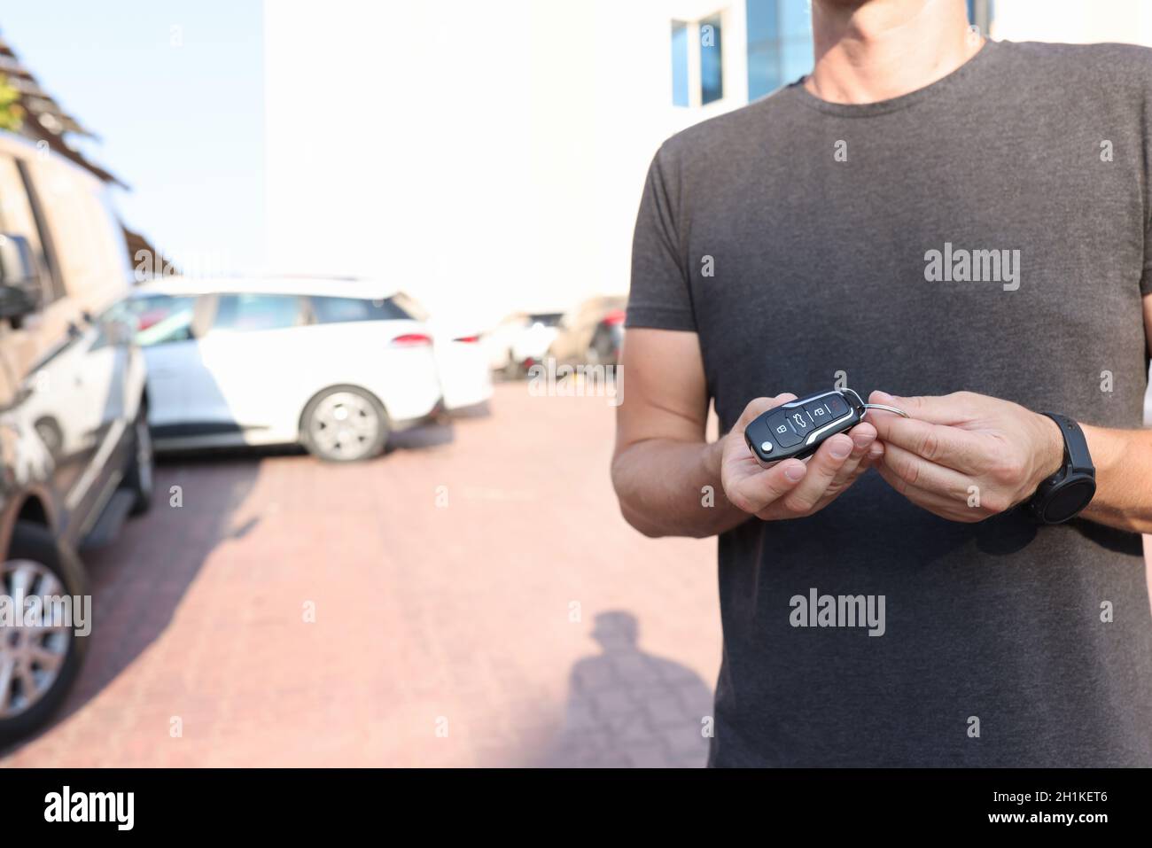 Man holds in hands push-button remote control from car closeup Stock Photo
