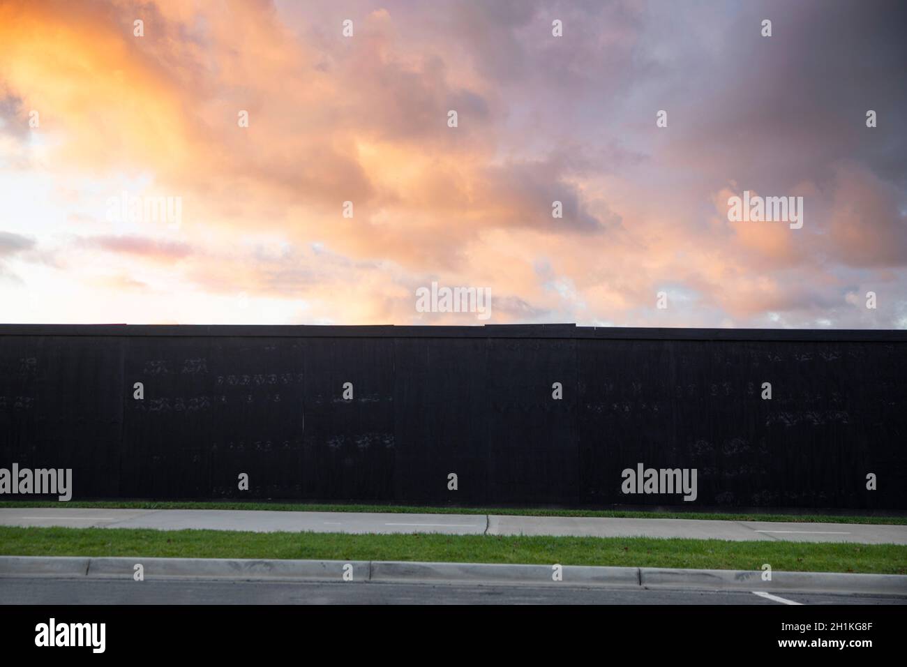 Timber hoarding wall surrounding construction site during dusk. Stock Photo