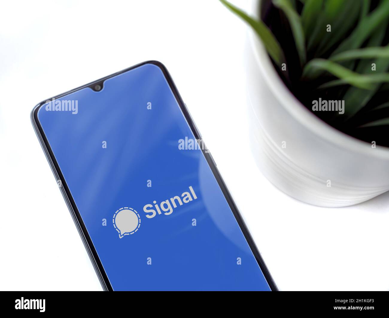 Lod, Israel - July 8, 2020: Modern minimalist office workspace with black mobile smartphone with Signal Private Messenger app launch screen with logo Stock Photo