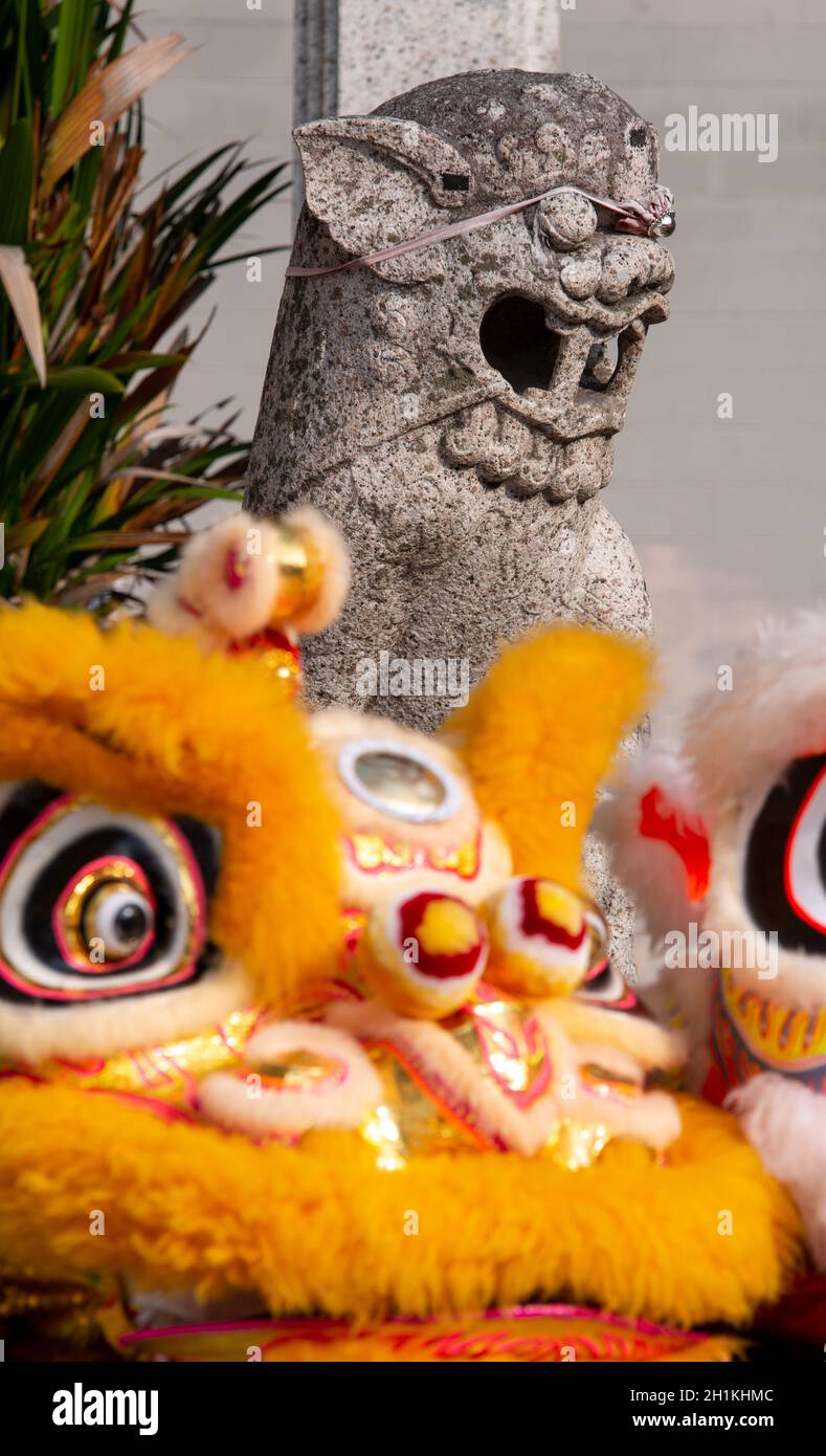 Old lion statue with front lion dance in front of temple at