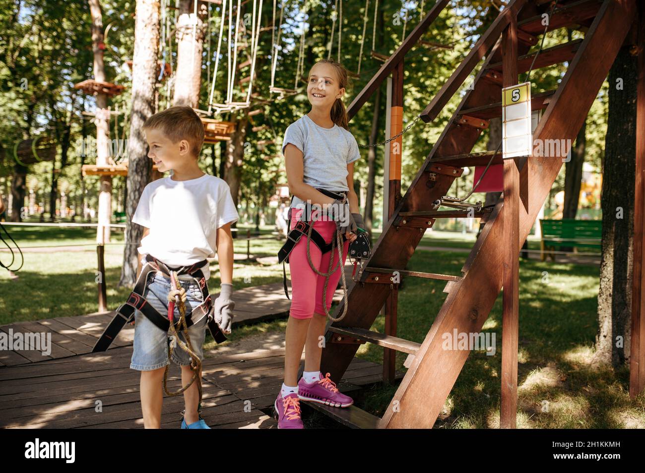 Little kids in equipment, rope park, playground. Children climbing on ...