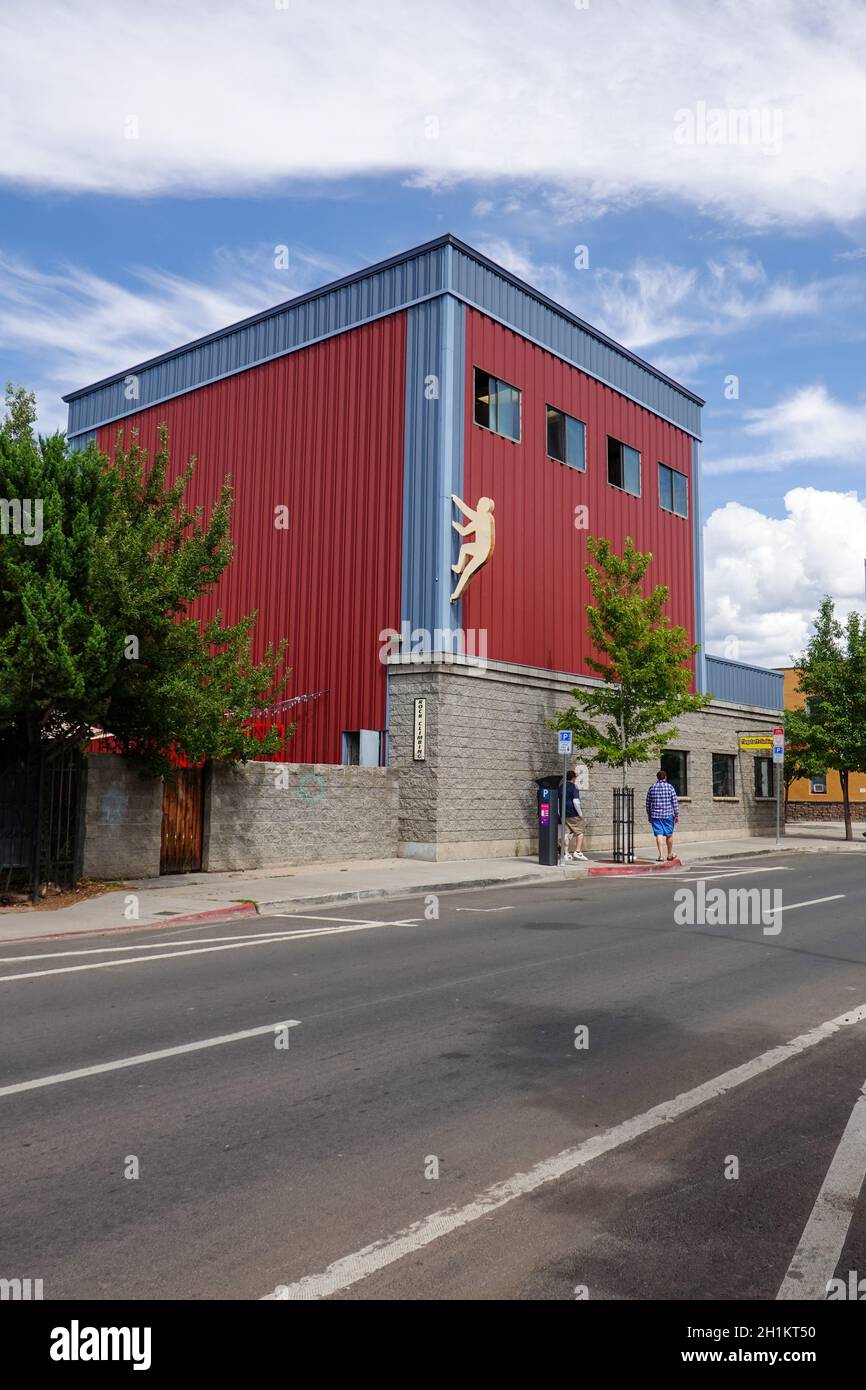 Two people walking down the street in front of a climbing gym in