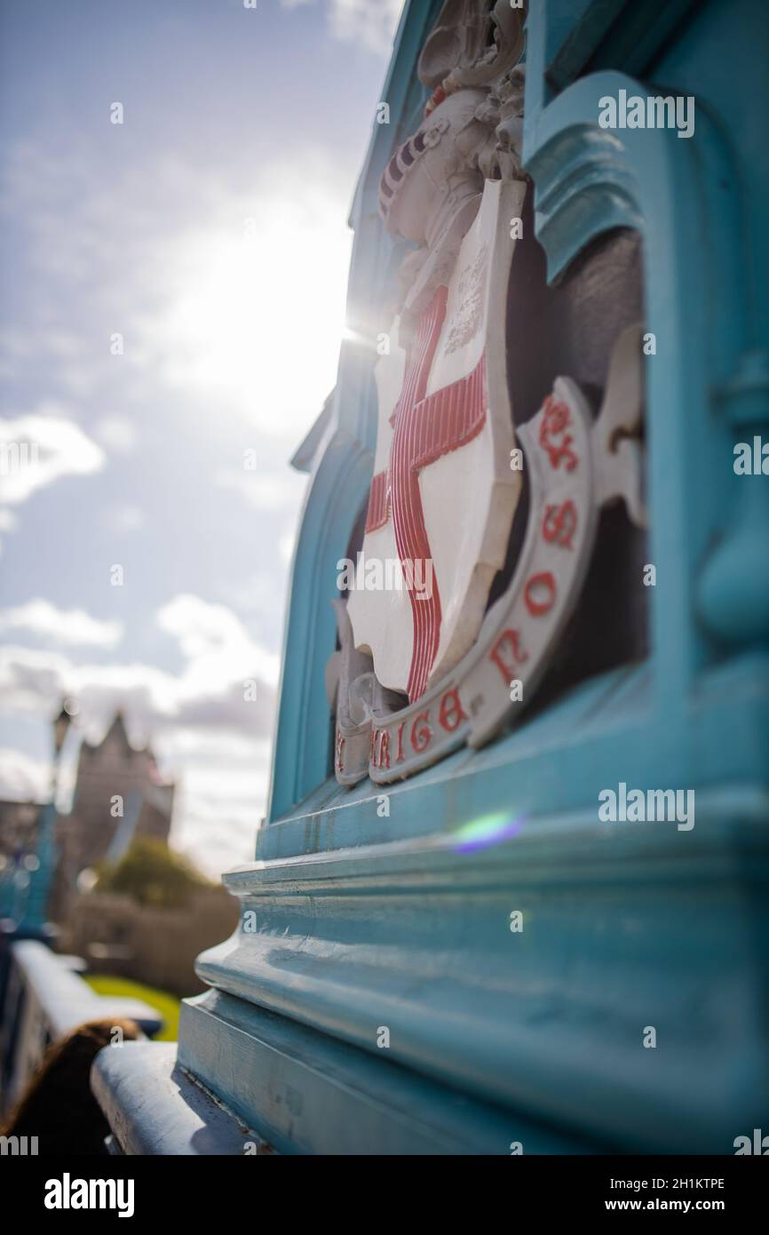 London, UK - September 30, 2020: Portrait lateral View of a blue Lamp with the London Coat of Arms from the Tower Bridge overshadowing the sun and wit Stock Photo