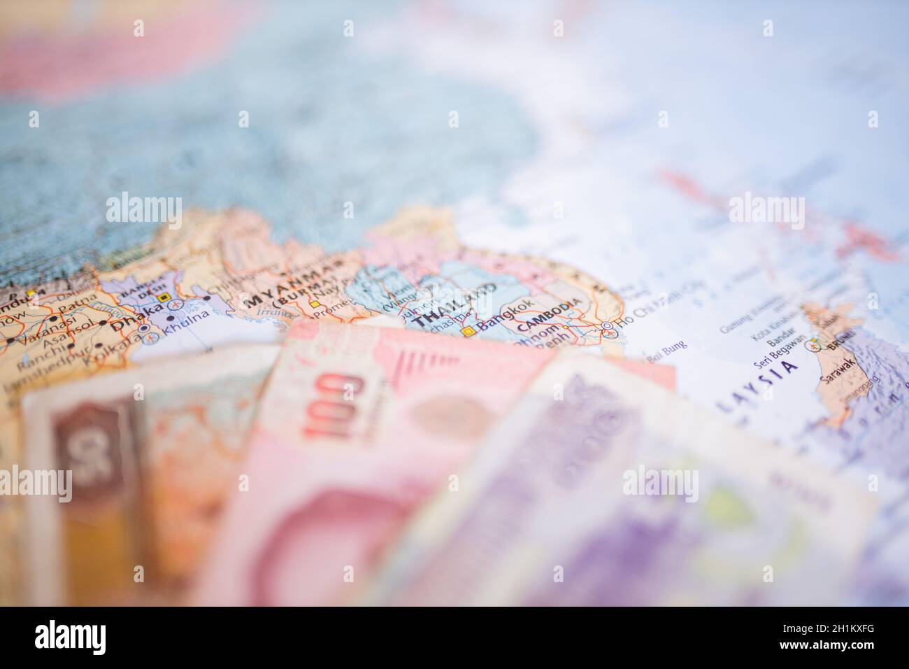 Close up picture of a blurry 50 Burmese kyat bill, a 100 Thai baht bill,  and a 100 riels bill next to Myanmar, Thailand, and Cambodia on a colorful  ma Stock Photo - Alamy