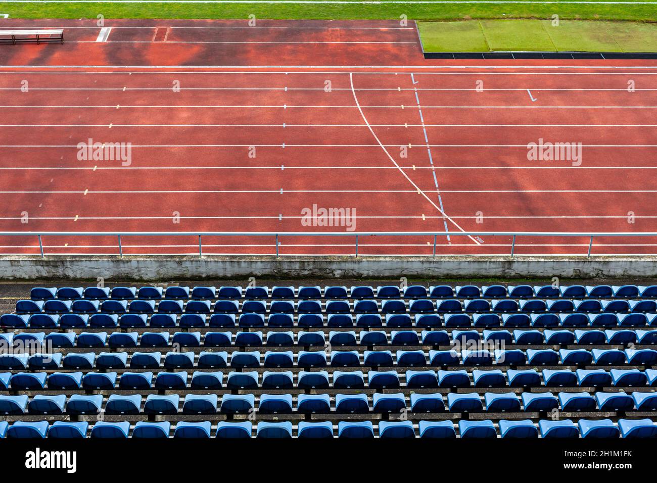empty auditorium in athletic stadium, rows of blue chairs. Stock Photo