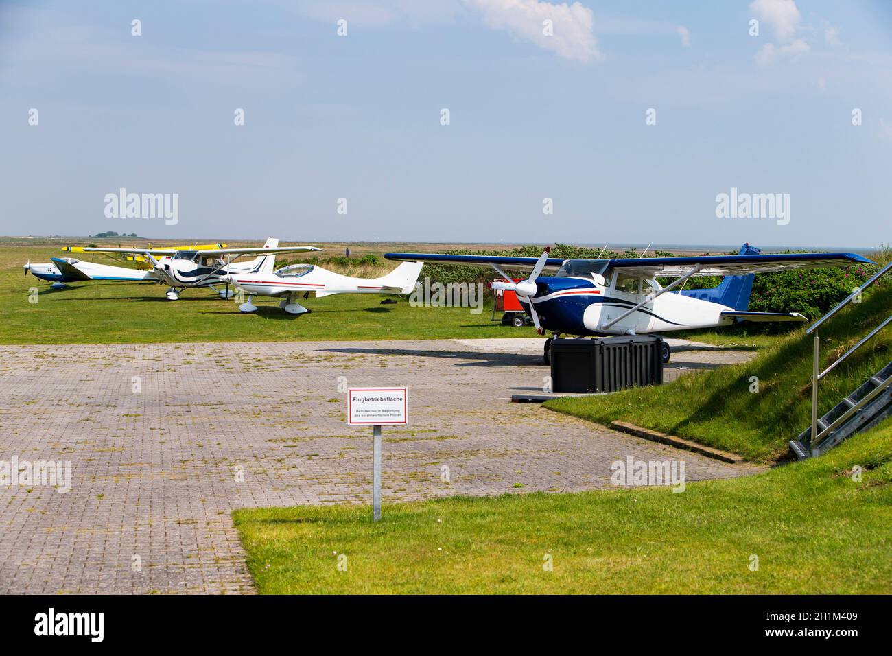 Das Foto den Baltrumer Flugplatz mit geparkten Flugzeugen bei Tageslicht Stock Photo