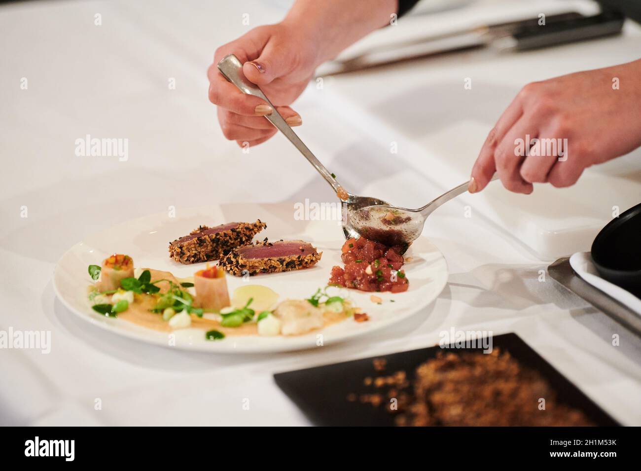 Berlin, Germany. 18th Oct, 2021. A waitress places tuna tartare on a
