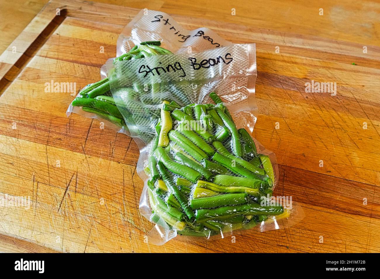 Two packages of fresh green beans vacuum sealed into bags Stock Photo
