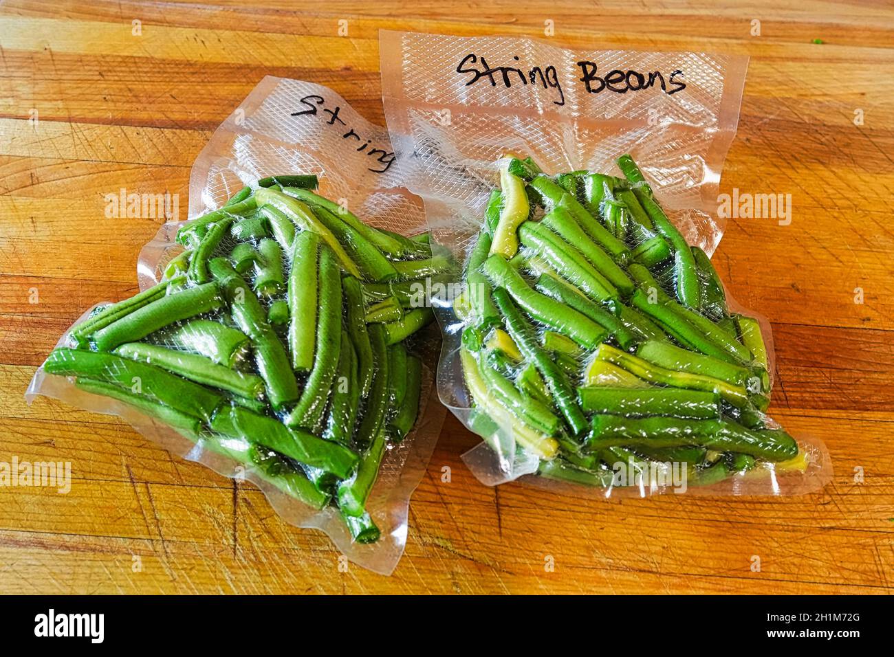 Two packages of fresh green beans vacuum sealed into bags Stock Photo