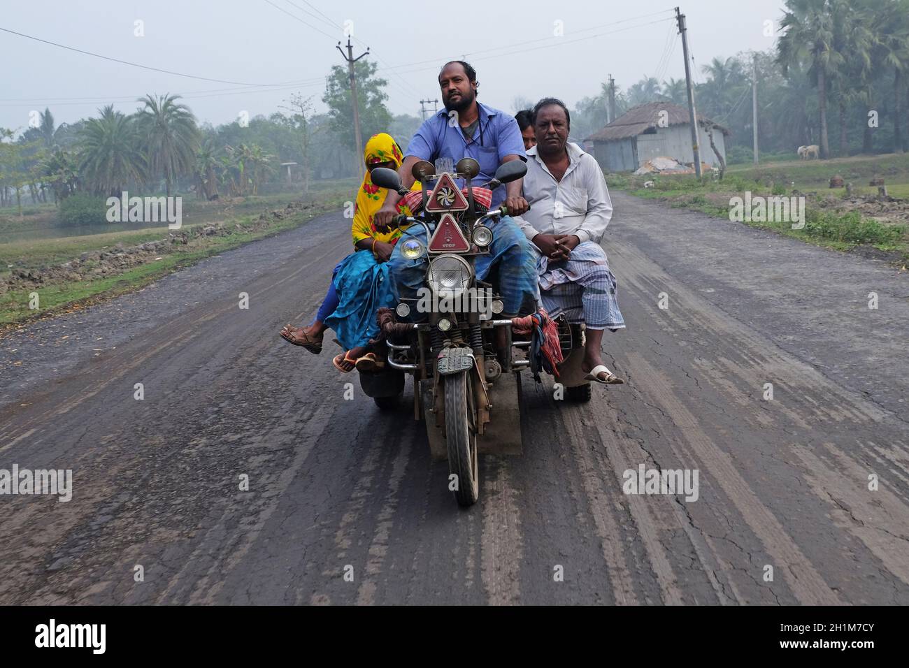 Indian tricycle motor rickshaw carrying passenger, Kumrokhali, West