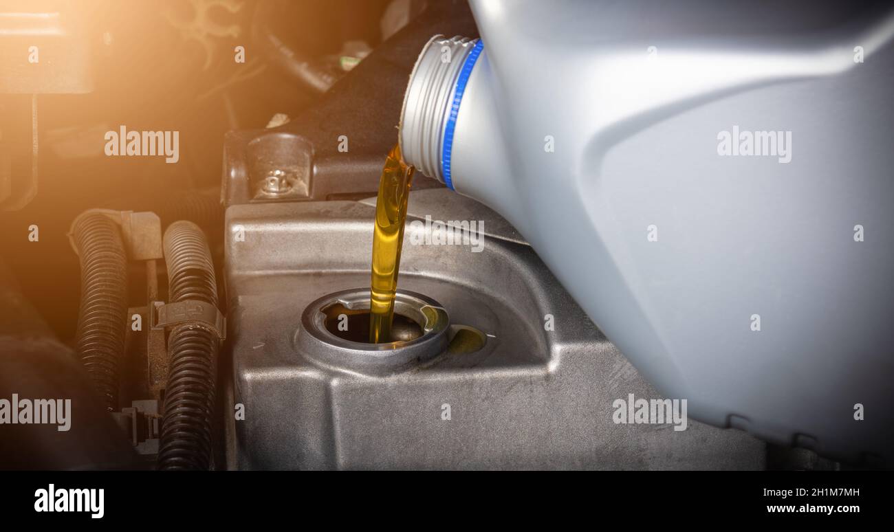 Mechanic in service to repair the car, refueling and pouring from