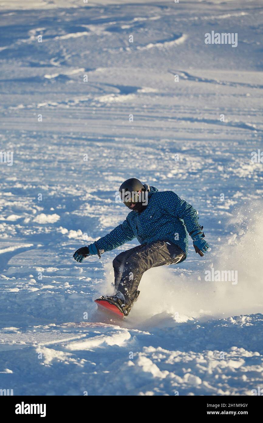 LES ORRES, FRANCE - CIRCA 2015: Young snowboarder coming down fast in fresh powder snow off-piste free ride. Stock Photo