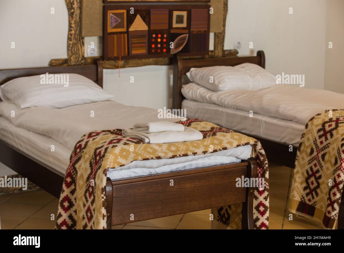 Exquisite Interior in a Cozy Place. Wooden Bed of a Modern Hotel Room. Stock Photo